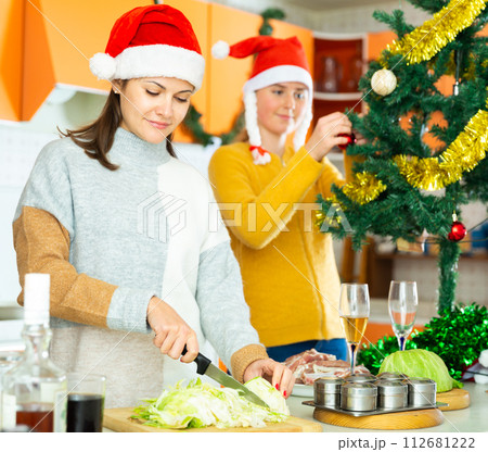 Young woman in cooking christmas dinner at home with sister 112681222