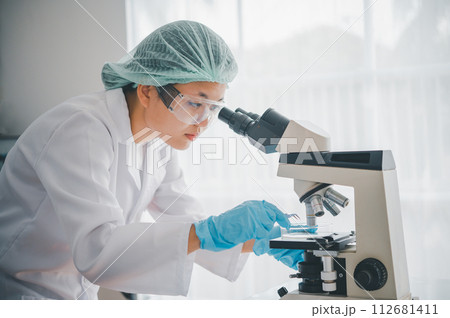 Female researchers are experimenting with pipette dropping a sample into a test tube in an experiment research in laboratory... Female researchers are experimenting with pipette dropping a sample into a test tube in an experiment research in laboratory... 112681411