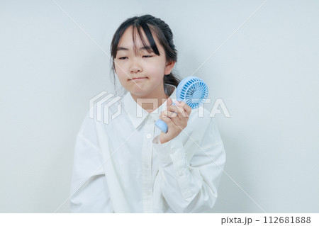 ハンディファンで涼む眠たそうな女の子 ハンディファンで涼む眠たそうな女の子 112681888