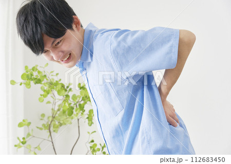 ぎっくり腰の若い男性 112683450