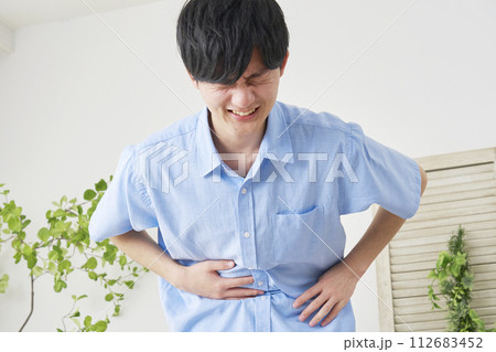 腹痛の若い男性 112683452