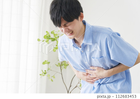 腹痛の若い男性 112683453