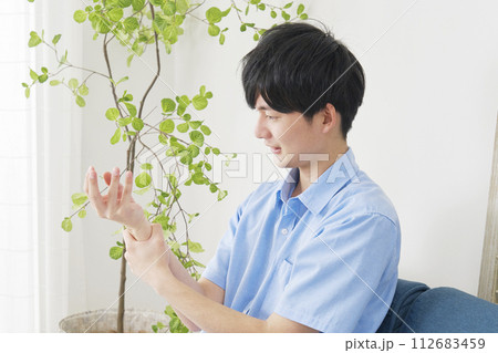 手が痺れる若い男性 112683459