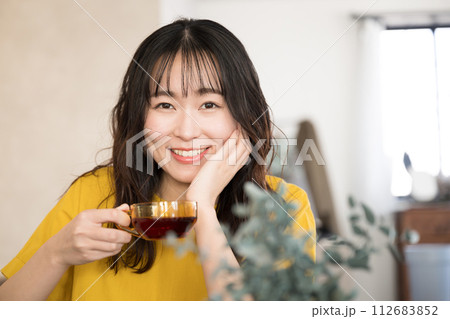 カフェや飲食店や自宅お茶を飲むリラックスする美しい女性クローズアップの正面　カメラ目線 112683852