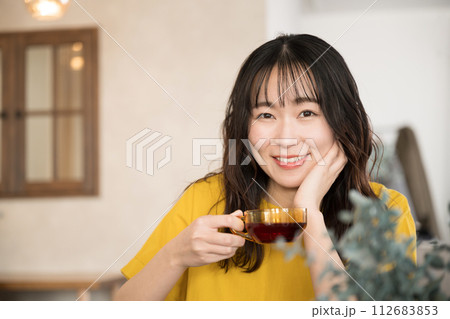 カフェや飲食店や自宅お茶を飲むリラックスする美しい女性クローズアップの正面　カメラ目線 112683853