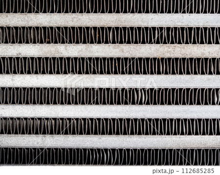 The metal grill of a car radiator is old and has scale marks 112685285