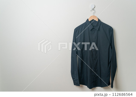 hanging shirt with wood hanger on wall 112686564