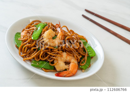 stir-fried yakisoba noodles with green peas and shrimps 112686766