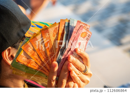 Cropped shot of woman hand holding a group of Sri Lanka banknotes in her hand. 112686864