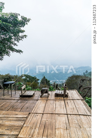 chair on balcony with mountain hill and foggy background 112687233