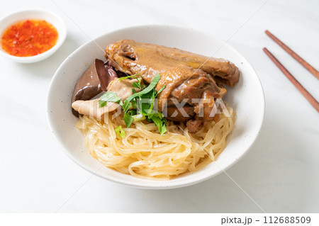 dried noodles with braised duck in white bowl 112688509