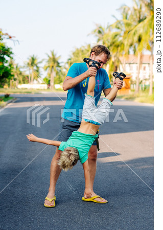 Father son have fun. Man holds child's leg upside down head. Joy happiness childhood paternity delight 112689290
