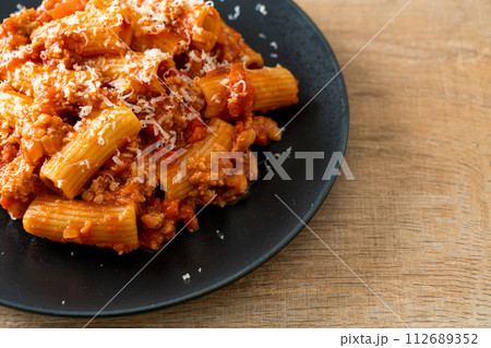 Rigatoni pasta bolognese with cheese 112689352