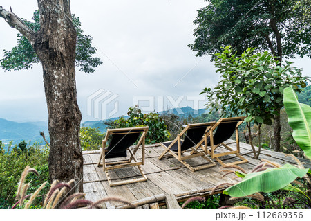 chair on balcony with mountain hill and foggy background chair on balcony with mountain hill and foggy background 112689356