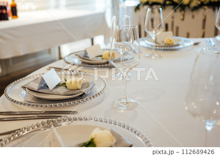 A very beautiful festive table with candles, plates and glasses. Cool room decor A very beautiful festive table with candles, plates and glasses. Cool room decor 112689426