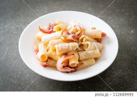 spaghetti rigatoni pasta with white sauce and bacon 112689495