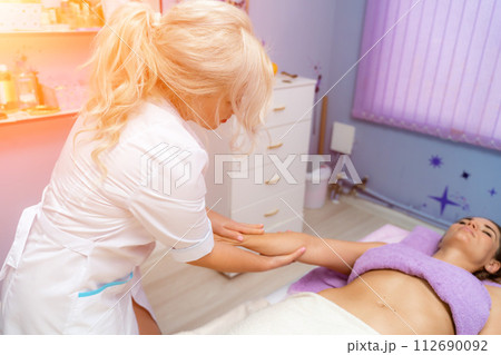 Blonde massage therapist massaging a woman. Woman getting a massage at the spa 112690092