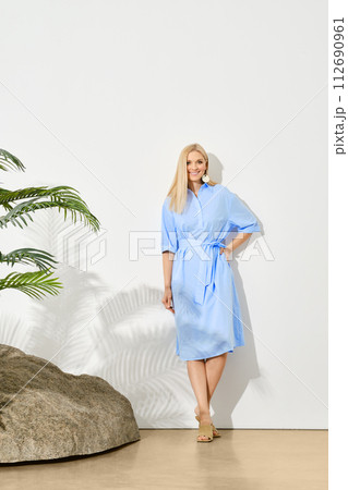 Beautiful woman in dress posing under palm leaves shade Beautiful woman in dress posing under palm leaves shade 112690961
