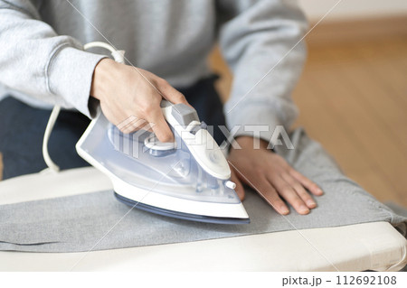 アイロンを掛ける男性　ボディパーツ　アイロン 112692108