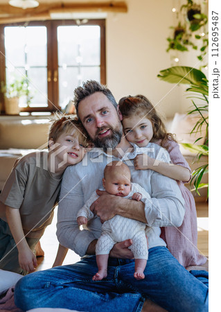 Portrait of father holding newborn baby, enjoying all his kids. New sibling. Unconditional paternal love, Father's Day concept. 112695487