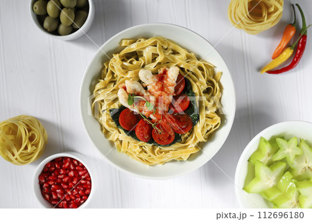 Noodles with spinach, tomatoes and shrimp. Seafood. Home production. Noodles with spinach, tomatoes and shrimp. Seafood. Home production. 112696180