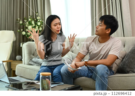 Stressed couple quarreling, arguing about serious financial problems at home 112696412