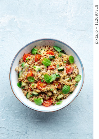 Quinoa tabbouleh salad in a bowl, a healthy dinner with tomatoes and mint Quinoa tabbouleh salad in a bowl, a healthy dinner with tomatoes and mint 112697518