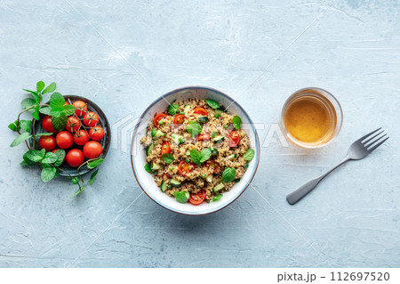 Quinoa tabbouleh salad in a bowl, a healthy dinner with tomatoes and mint 112697520
