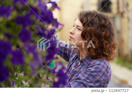 happy female nursery worker trimming plants in greenhouse happy female nursery worker trimming plants in greenhouse 112697727