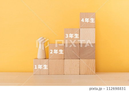 1年生、2年生、3年生、4年生の文字が入ったブロックと人形 112698831