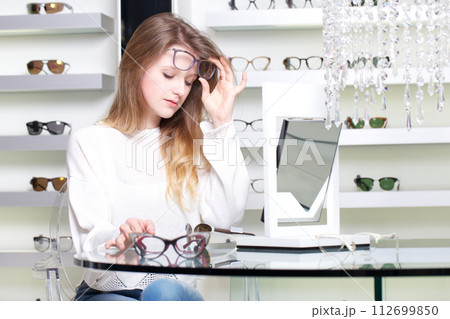 pretty girl buy a new pair of eyeglasses 112699850