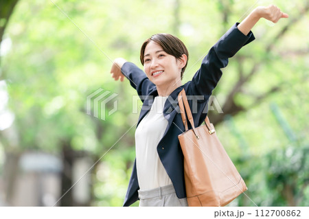 新緑で伸びをする女性 112700862