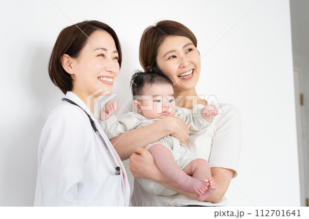 赤ちゃんを抱いた母親と女性医師 赤ちゃんを抱いた母親と女性医師 112701641