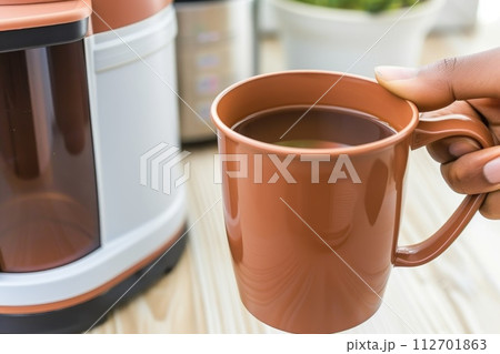 Coffee is poured into a cup. morning coffee Coffee is poured into a cup. morning coffee 112701863