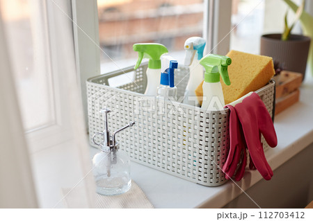Close up of basket with cleaning supplies by window Spring cleaning concept copy space Close up of basket with cleaning supplies by window Spring cleaning concept copy space 112703412