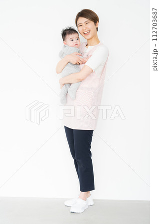 0歳の赤ちゃんを抱く保育士 0歳の赤ちゃんを抱く保育士 112703687