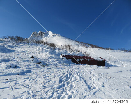 厳冬期の磐梯山(登山道から見える弘法清水小屋と山頂) 112704366