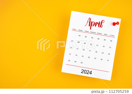 April 2024 calendar page with red push pin on yellow. 112705259