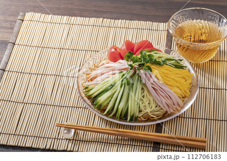 竹のランチョンマットを敷いてガラス皿に盛った夏の定番冷やし中華 112706183