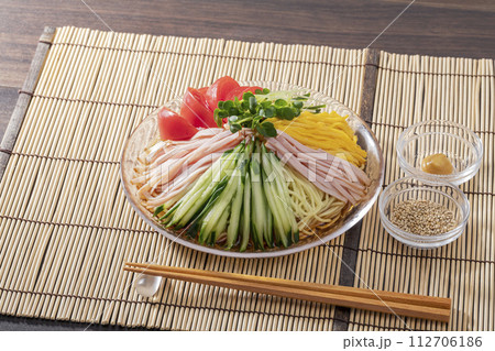 竹のランチョンマットを敷いてガラス皿に盛った夏の定番冷やし中華 112706186