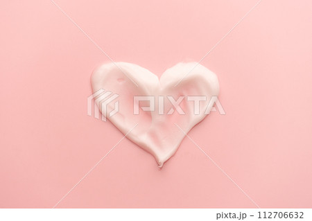 Heart shape skincare cream smear on pink background. Cosmetic lotion swatch texture of face cream, body moisturiser and hair conditioner. Beauty and cosmetic product. 112706632
