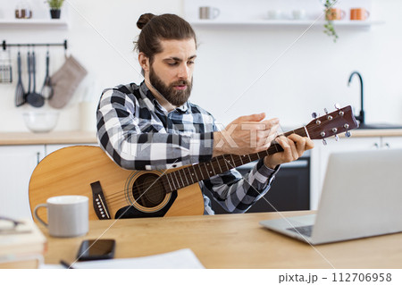 Happy male teaching online guitar lesson using modern technologies. 112706958