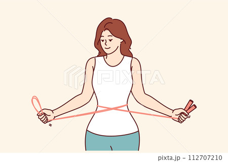 Fitness woman training with jump rope in hands, showing off slender figure and thin waist Fitness woman training with jump rope in hands, showing off slender figure and thin waist 112707210