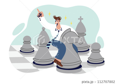 Business man plays chess sitting astride knight chess piece, demonstrating strategic thinking 112707802
