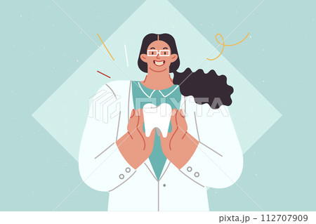 Woman dentist demonstrates large human tooth calling for attention to oral diseases Woman dentist demonstrates large human tooth calling for attention to oral diseases 112707909
