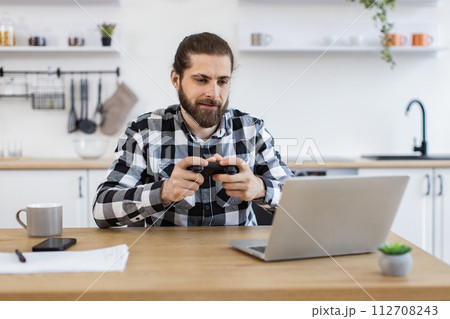 Male freelancer taking break and plays video games after work. Male freelancer taking break and plays video games after work. 112708243