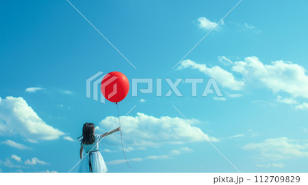 風船を持って青空を見上げる少女 112709829