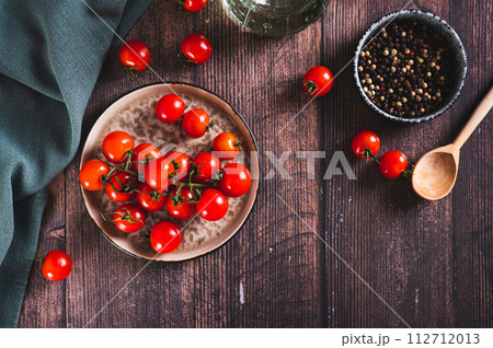 Branch of fresh ripe cherry tomatoes on a plate on the table top view 112712013