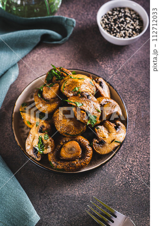 Homemade grilled mushrooms with herb on a plate on the table vertical view 112712033