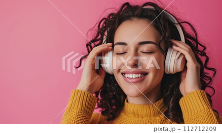 Young happy woman in headphones listen to music with closed eyes have fun isolated on plain pink background, studio portrait. People lifestyle concept 112712209
